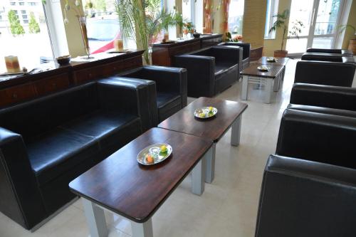 a restaurant with black chairs and a table with food on it at Hotel Golden Spirit in Băile Herculane