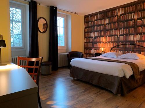 a bedroom with a large bed and bookshelves at AUBERGE DU PORCHE in Blaye
