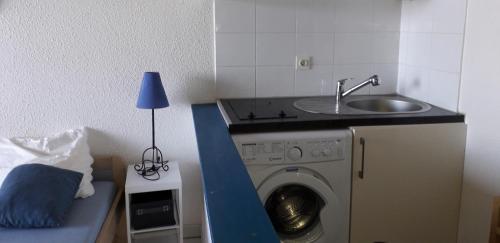 une cuisine avec une machine à laver et un évier dans l'établissement Résidence les Marines de Moriani Emeraude Locations, à Moriani-Plage