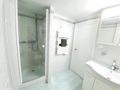 bagno bianco con doccia e lavandino di Esmeralda, Benidorm Beachfront Poniente, 1st line Frontal Seaview, Ocean Terrace a Benidorm