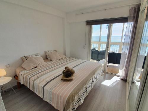 una camera da letto con un letto con un orsacchiotto sopra di Esmeralda, Benidorm Beachfront Poniente, 1st line Frontal Seaview, Ocean Terrace a Benidorm