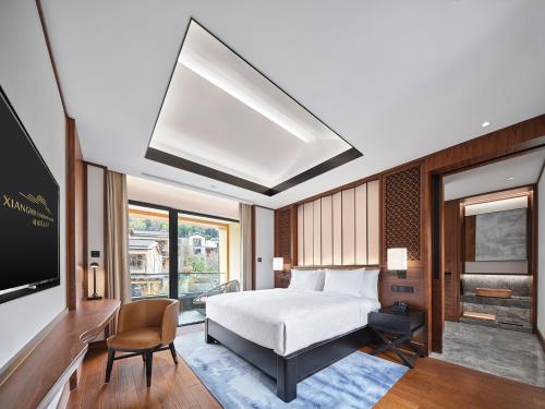 a bedroom with a bed and a tv and a couch at Xianghu Xiaoyao Manor in Xiaoshan