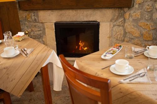 two tables in front of a fireplace in a restaurant at La Casona de Cardes in Cangas de Onís