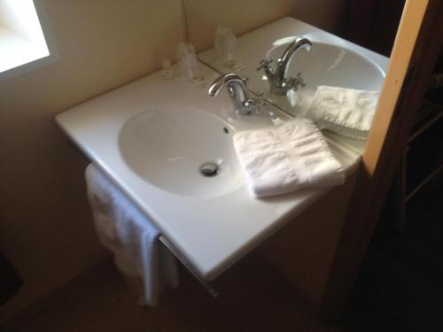 um lavatório de casa de banho com duas toalhas brancas em Hotel du Commerce em Cholet