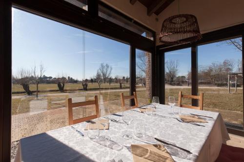 a dining room with a table and large windows at Casa Di Anna - Fattoria Sociale in Mestre