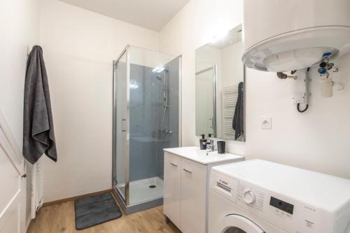 uma casa de banho branca com um chuveiro e uma máquina de lavar roupa em T2 BASQUE BAYONNE em Baiona