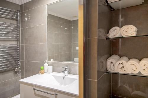 een badkamer met een wastafel, een spiegel en handdoeken bij P18 Villalia Apartamento B en la Isla de la Toja in Isla de la Toja