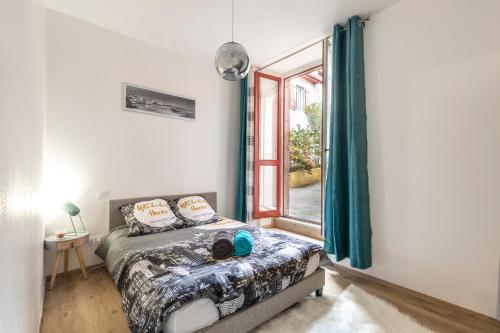 um quarto com uma cama e uma janela em T2 BASQUE BAYONNE em Baiona