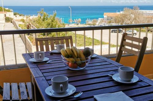 a table with a bowl of fruit on a balcony at Cala Mesquida in Cala Mesquida