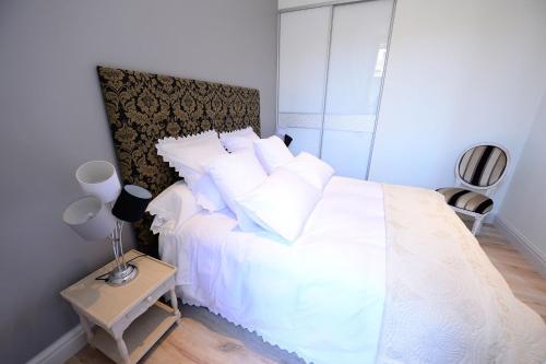 a bedroom with a white bed with white pillows at Bordeaux Design Apartments in Bordeaux