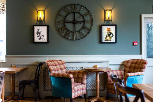 Coach House Inn في دورتشستر: مطعم فيه ساعة على الحائط وكراسي