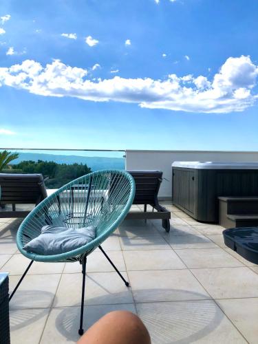 a chair sitting on top of a building with a view at Bubbles Penthouse with Jacuzzi in Podstrana
