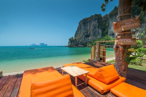 a deck with chairs and a table and the beach at Tinidee Hideaway Tonsai Beach Krabi - SHA Extra Plus in Tonsai Beach