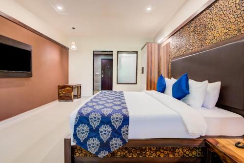 a bedroom with a large bed with blue and white pillows at Club Mahindra Netrang in Netrang
