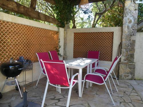 a table and chairs on a patio with a grill at Maisonnette au calme et proche mer in Mandelieu-la-Napoule