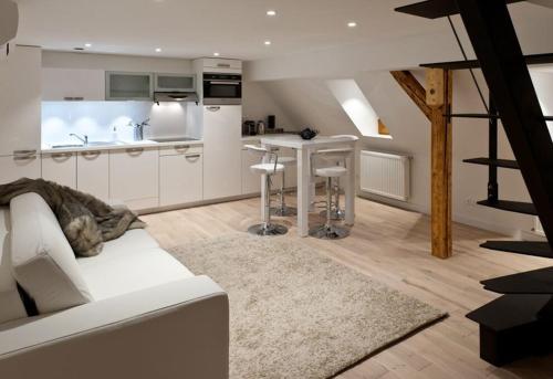 un salon avec un canapé blanc et une cuisine dans l'établissement Appartements Le Dome - Quartier Cathédrale, à Strasbourg