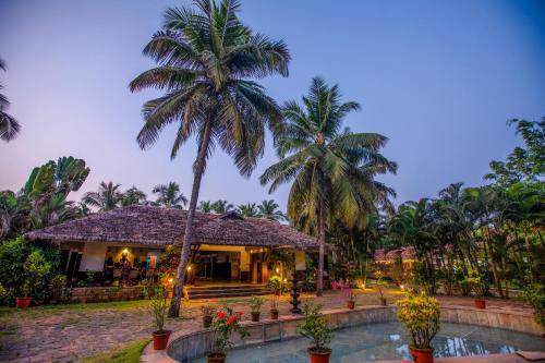 a resort with a swimming pool and palm trees at Malabar Ocean Front Resort And Spa, Bekal in Nīleshwar