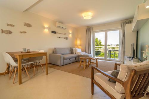 a living room with a couch and a table at Apartamento VerdeMar Cabanas Gardens by Your Home Algarve in Cabanas de Tavira