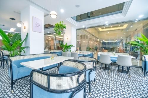 a restaurant with blue and white chairs and tables at Bao Son International Hotel in Hanoi
