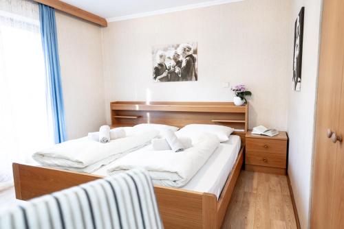 1 dormitorio con 2 camas con sábanas blancas en Haus Bergfrieden Seiser Alm, en Siusi