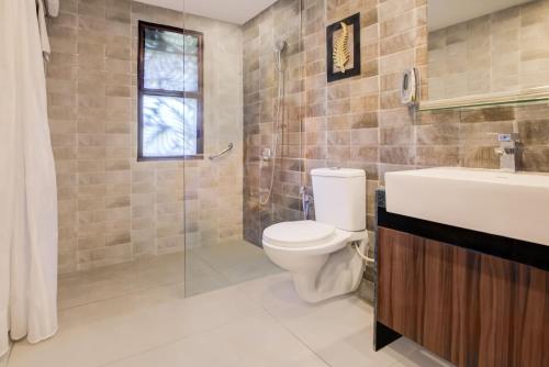 a bathroom with a toilet and a sink and a shower at Club Mahindra Netrang in Netrang