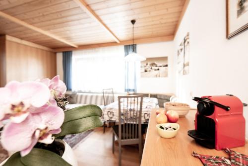 a living room with a table with a red suitcase at Haus Bergfrieden Seiser Alm in Siusi