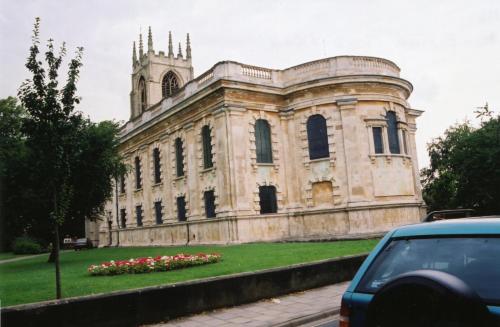 ein altes Steingebäude mit einem Uhrturm und Blumen in der Unterkunft Gainsborough Hotel in Gainsborough