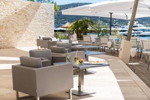 a restaurant with tables and chairs and umbrellas at Hotel Don Cesar in Porto-Vecchio
