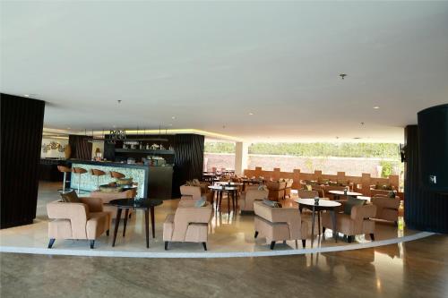 a restaurant with tables and chairs in a room at b Hotel Bali & Spa in Denpasar
