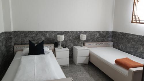 a bedroom with two beds and two night stands at Hotel Ko in Düsseldorf