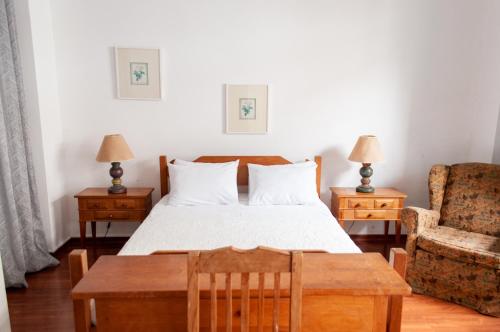 a bedroom with a bed and a couch and a chair at Pousada Richard Rothe in Tiradentes