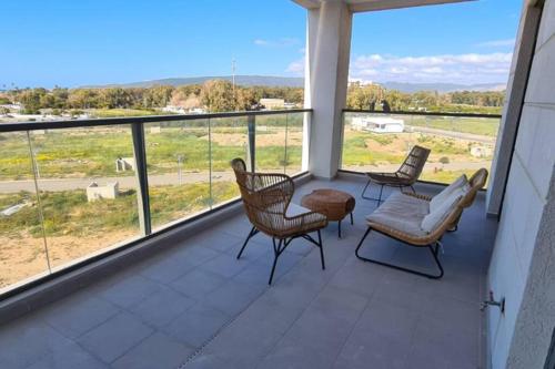 a balcony with chairs and a view of a field at 4 Bedroom Beach Apartment with Stunning Views in Nahariyya