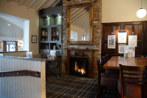 a fireplace in a restaurant with a table and a mirror at Boat & Horses Inn in Oldham
