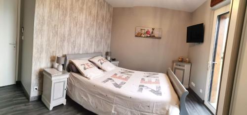 Dormitorio pequeño con cama y TV en Maison en ossature bois en Plaintel