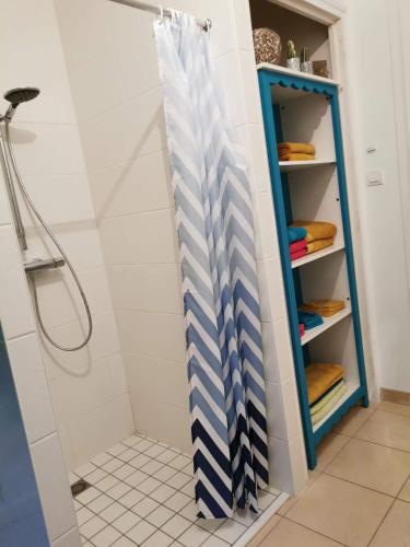 un rideau de douche à rayures bleues et blanches dans l'établissement Maison en ossature bois, à Plaintel