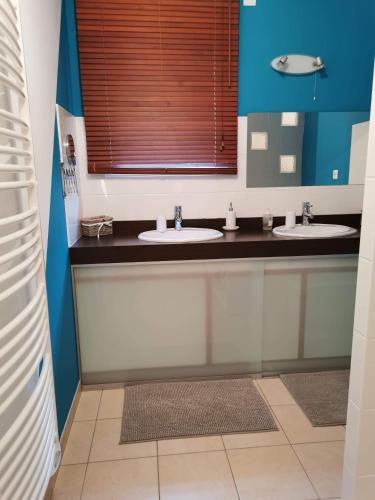 baño con 2 lavabos y ventana en Maison en ossature bois en Plaintel