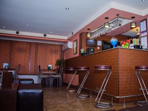 a bar in a restaurant with bar stools at Pensiunea Europa in Reşiţa