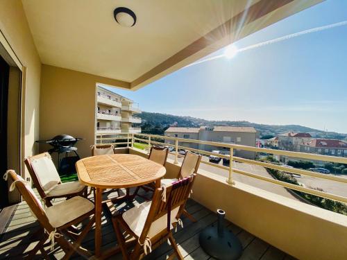 un balcon avec une table et des chaises et une vue dans l'établissement Les Jardins de Quatrina 2 chambres vue mer, à Propriano