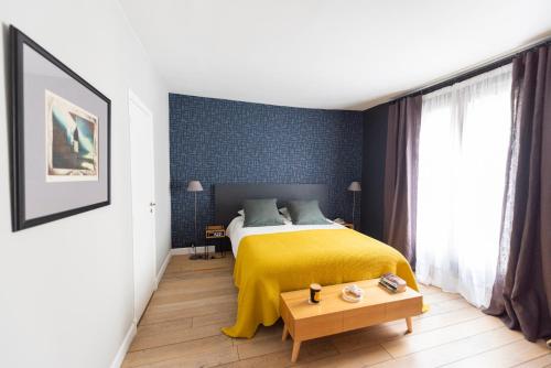 une chambre avec un lit avec une couverture jaune dans l'établissement Parador, à Paris