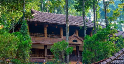 a house in the middle of a forest at Kalpavanam Heritage Resort in Thekkady