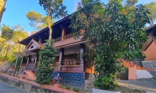 a house with trees in front of it at Kalpavanam Heritage Resort in Thekkady