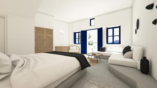 1 dormitorio blanco con 1 cama grande y 1 sofá en Oia Memories Suites, en Oia