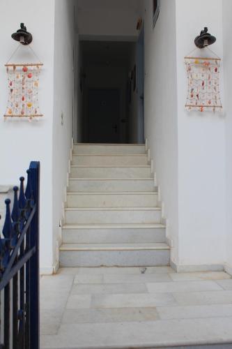korytarz ze schodami i czarnymi drzwiami w obiekcie Hippocampus Studios 2' walk from the sea w mieście Moutsoúna