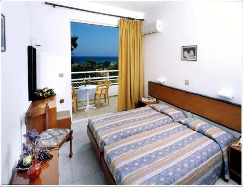 a hotel room with a bed and a balcony at Asterias Bay-Theologos in Theologos