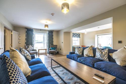 a living room with blue couches and a wooden table at Cilrhiw Country House - Princes Gate in Narberth