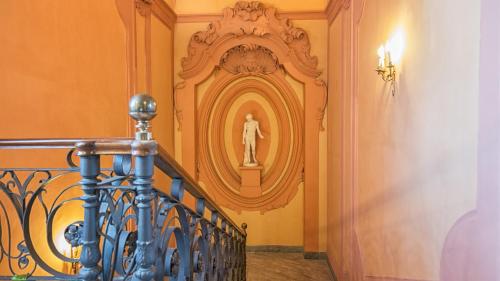 a hallway with a staircase with a statue on the wall at Villa Signorini Hotel in Ercolano