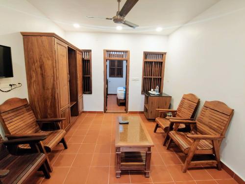 a living room with two chairs and a table at Kalpavanam Heritage Resort in Thekkady