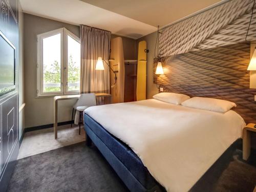 オルレアンにあるイビス オルレアン サントル ガルの大きなベッドと窓が備わるホテルルームです。