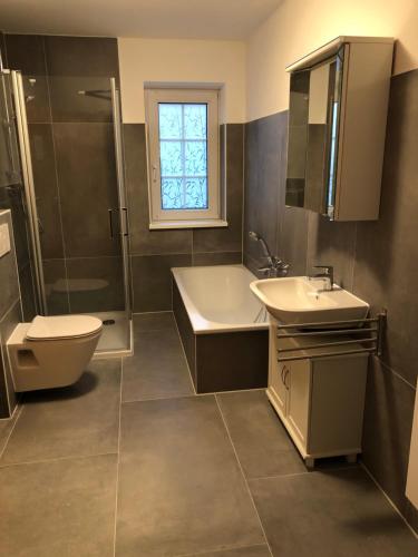 ein Badezimmer mit einem Waschbecken, einer Badewanne und einem WC in der Unterkunft Alter Ortskern Worpswede in Worpswede