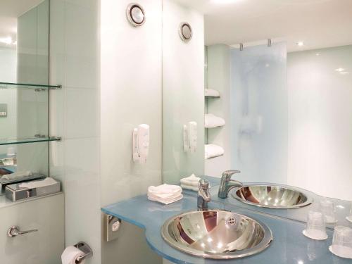 a bathroom with two sinks and a mirror at ibis Swansea in Swansea